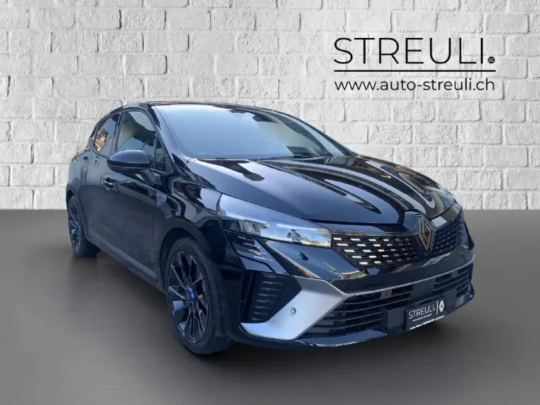 Schrägansicht von vorne links auf einen schwarzen Renault Clio Esprit Alpine E-Tech Full Hybrid vor weisser Steinwand.