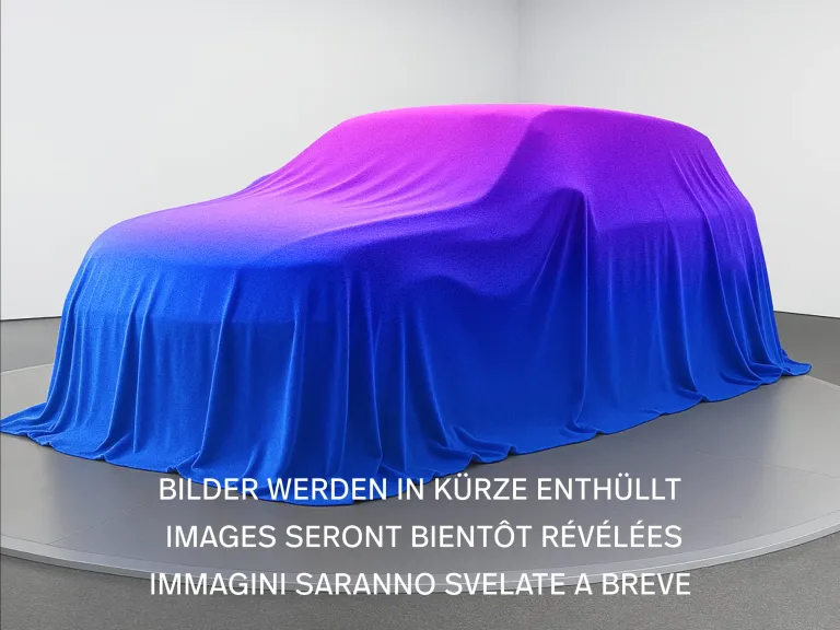 Ein verhülltes Fahrzeug unter einem blau-violetten Tuch auf einer Drehscheibe